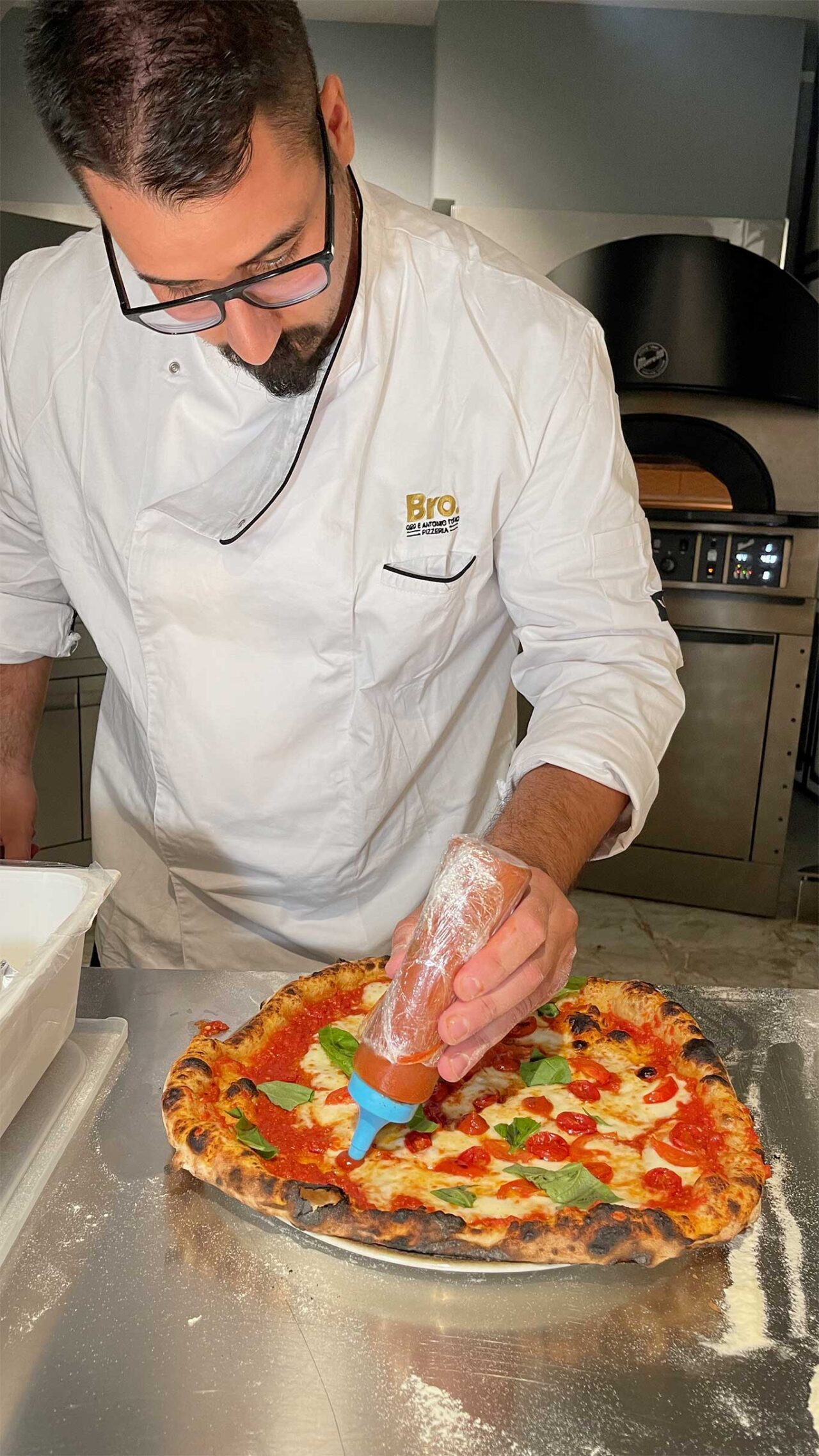 La rifinitura della pizza Fattore Umano della pizzeria Bro a Napoli
